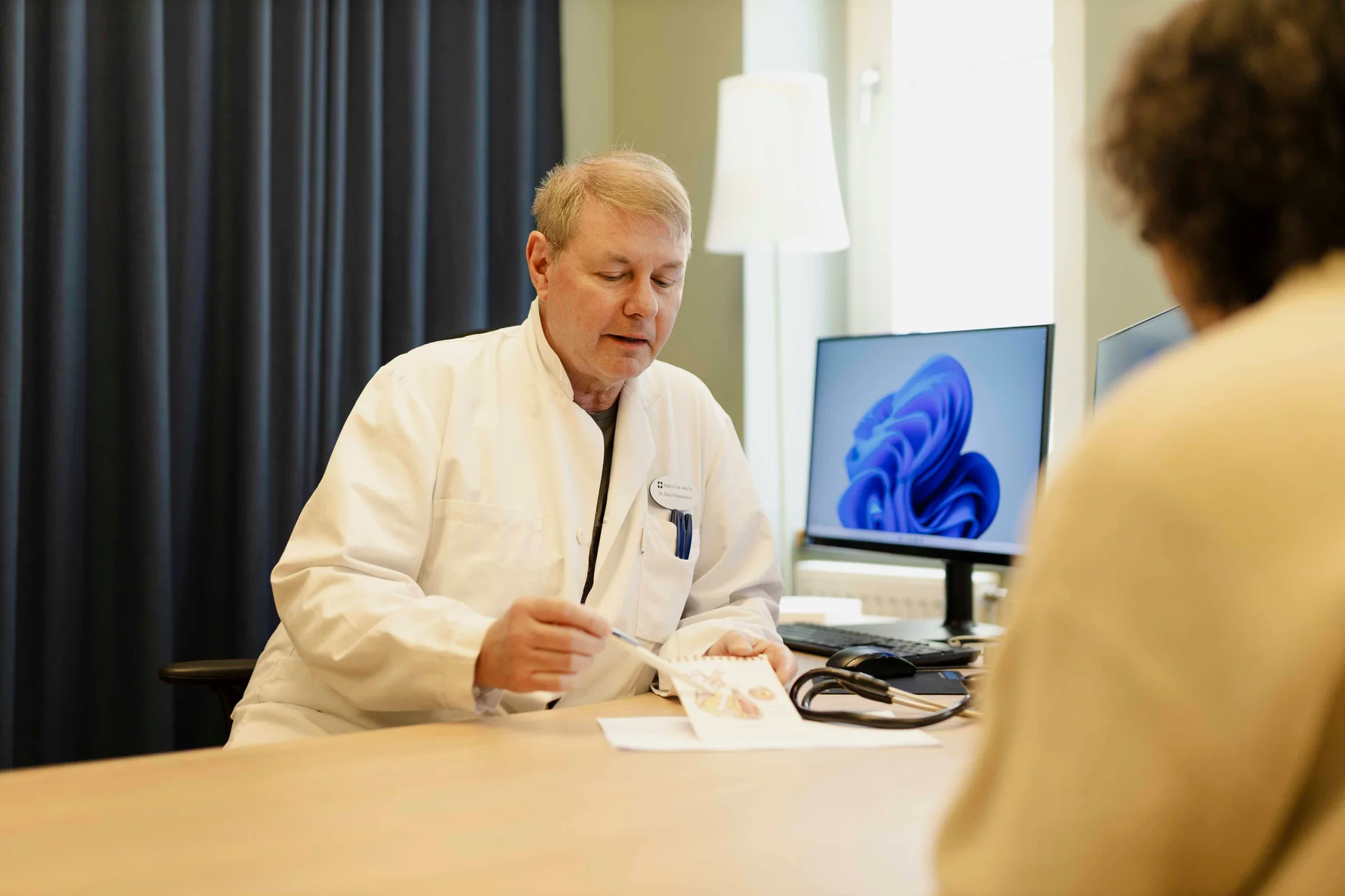 Executive Health doctor reviewing screening results with a patient.
